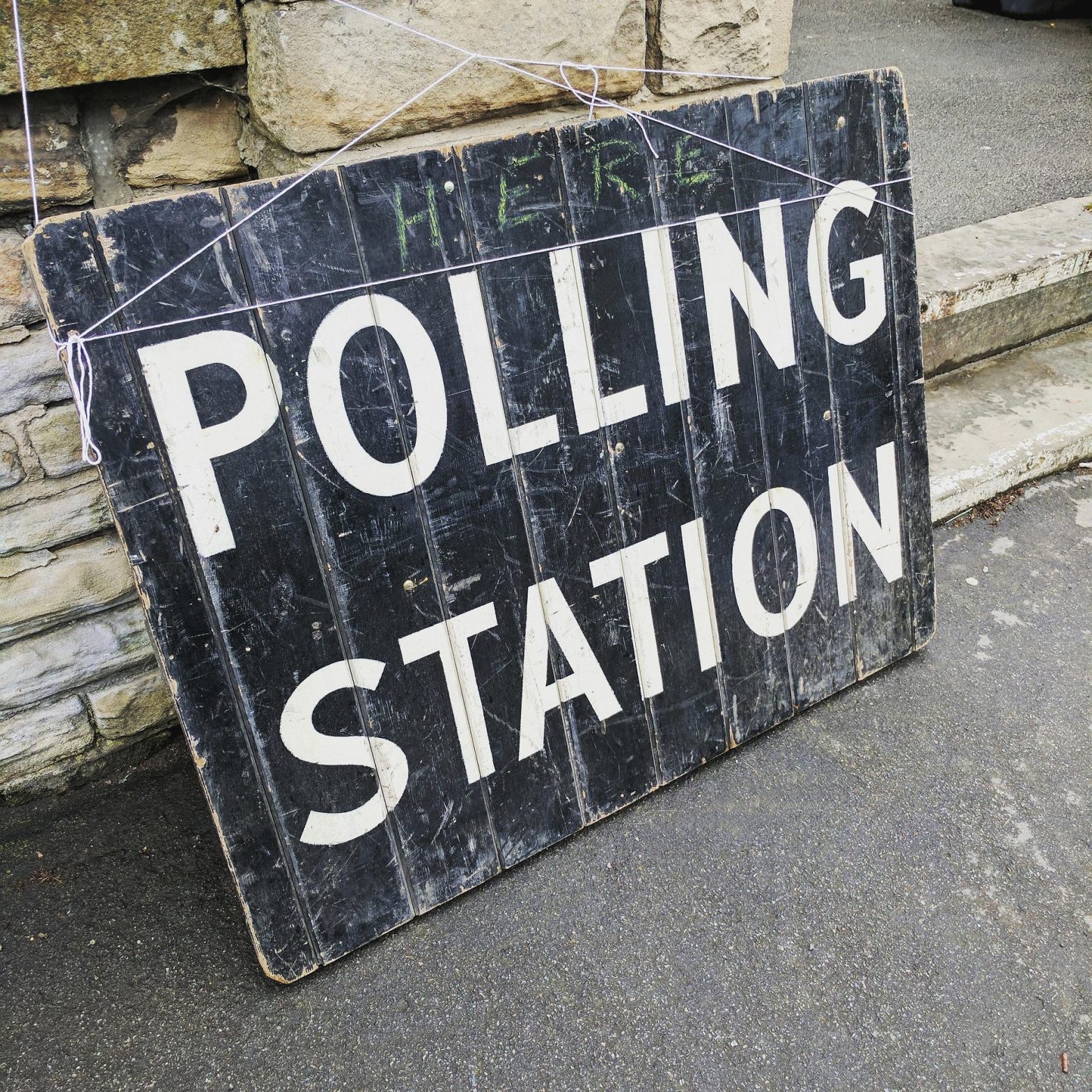 Large sign on ground with text: Polling Station